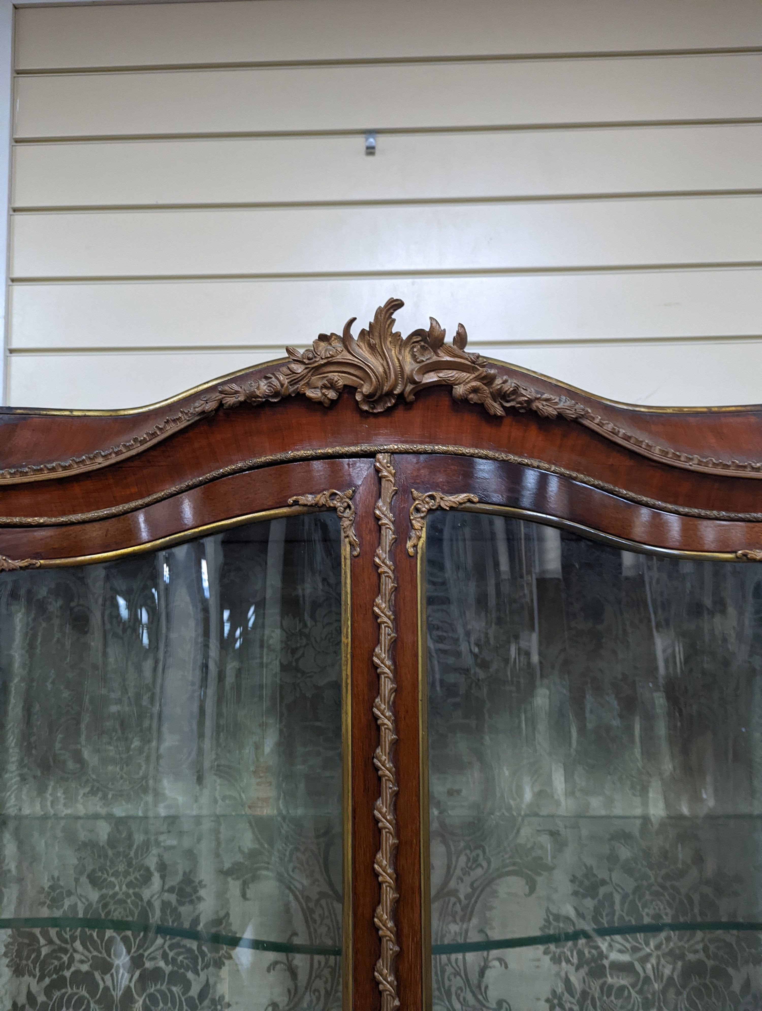 A Louis XV style mahogany serpentine vitrine with Vernis Martin style panels and gilt metal mounts, width 108cm, depth 46cm, height 193cm
